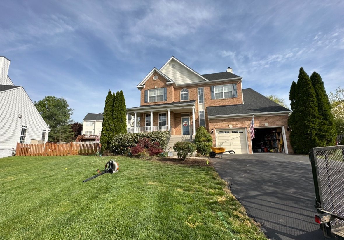A large brick house with a large lawn in front of it.