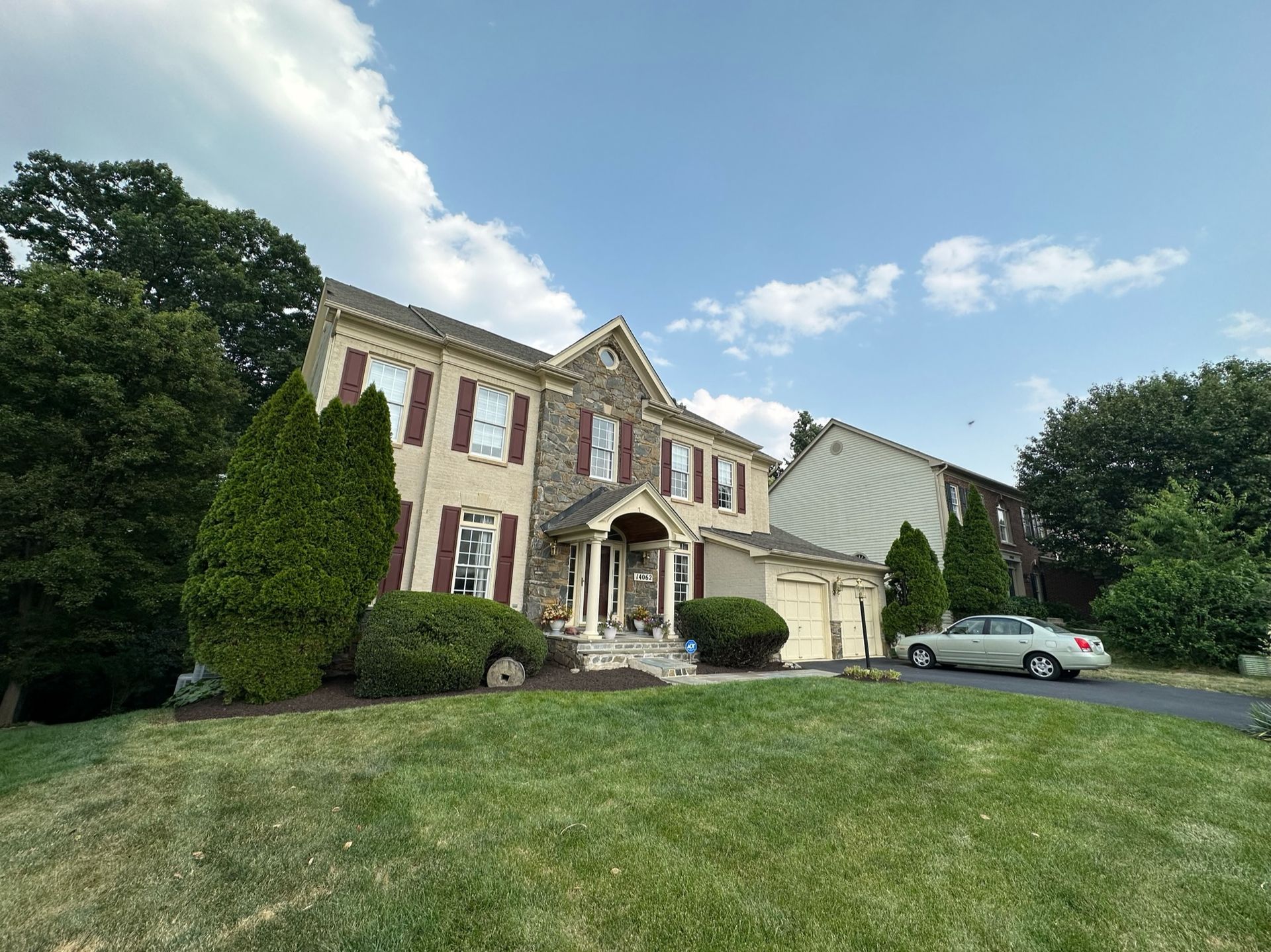 A large house with a car parked in front of it.