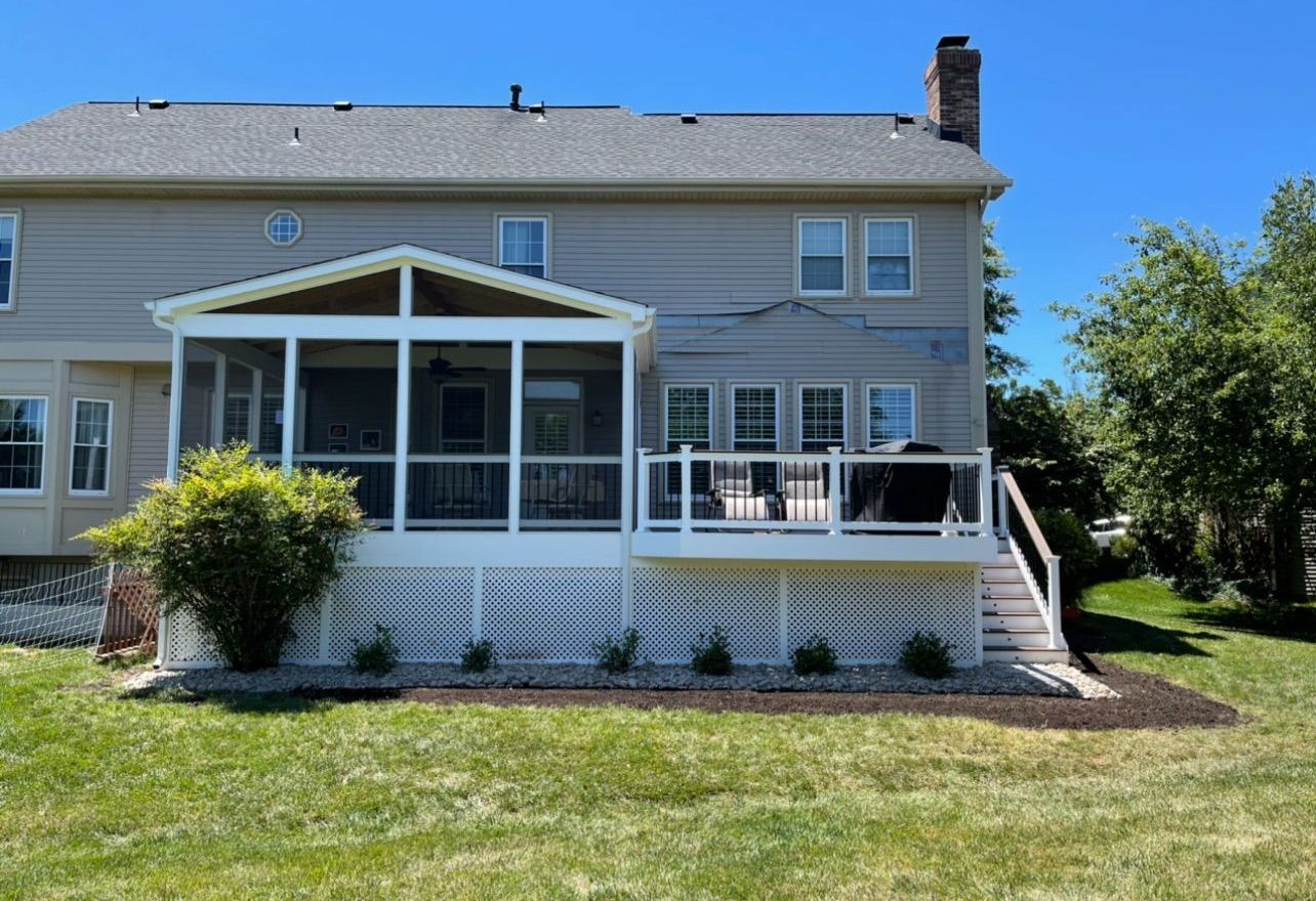 The back of a house with a screened in porch.