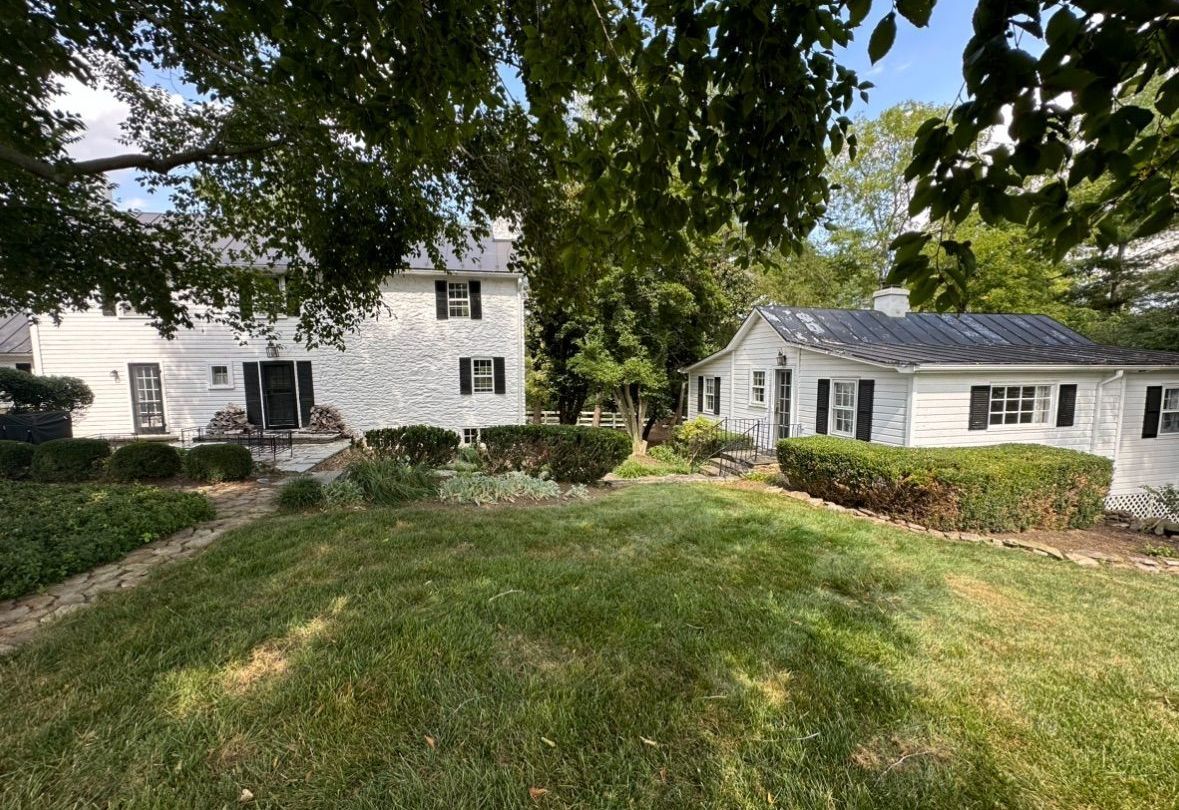 A large white house with a large lawn in front of it.