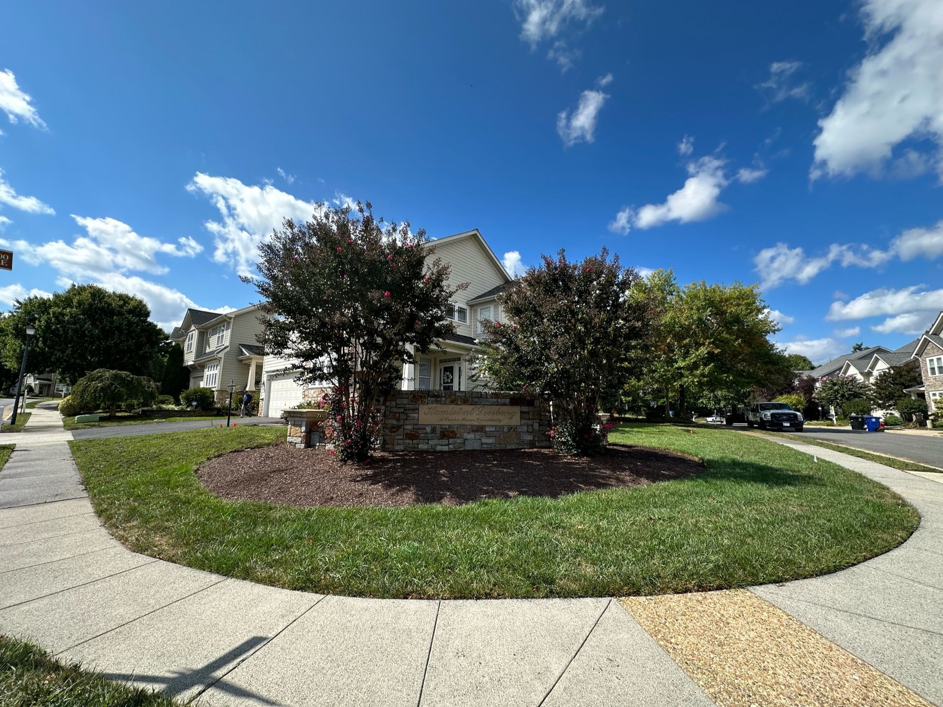 A house with a circular lawn in front of it in a residential neighborhood.