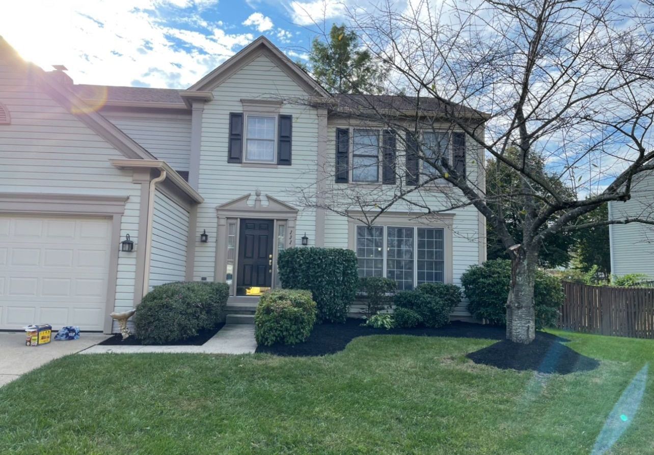 A large white house with a tree in front of it