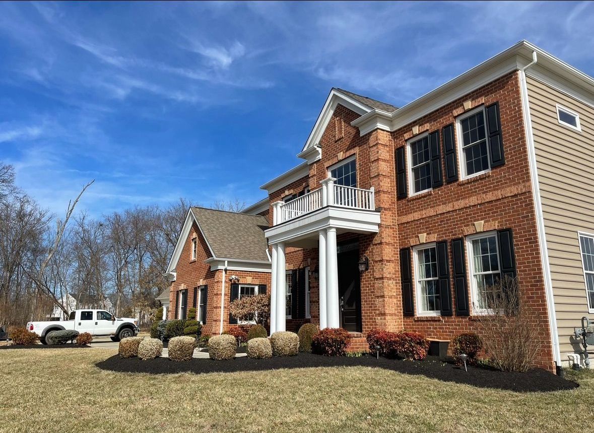 A large brick house with a white truck parked in front of it.