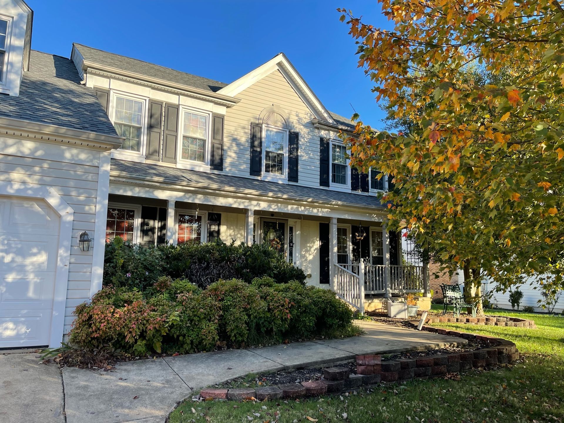 A large white house with a tree in front of it.