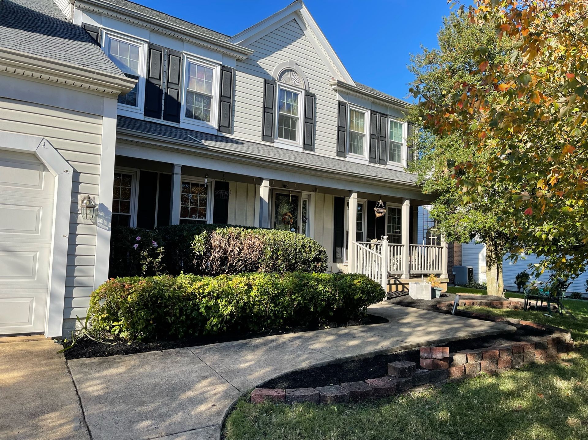 A large white house with a porch and a driveway