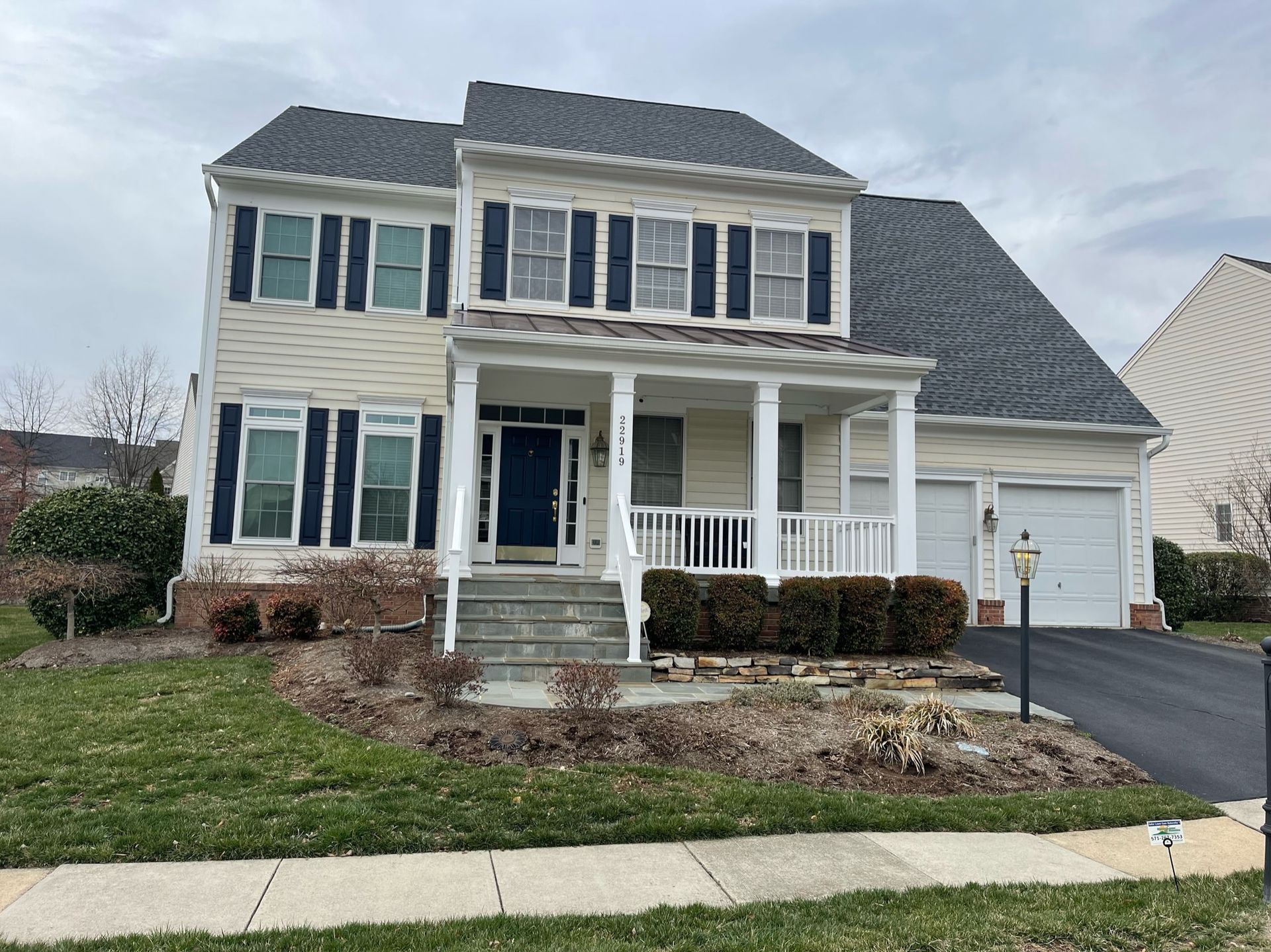 A large white house with a blue door and a porch.