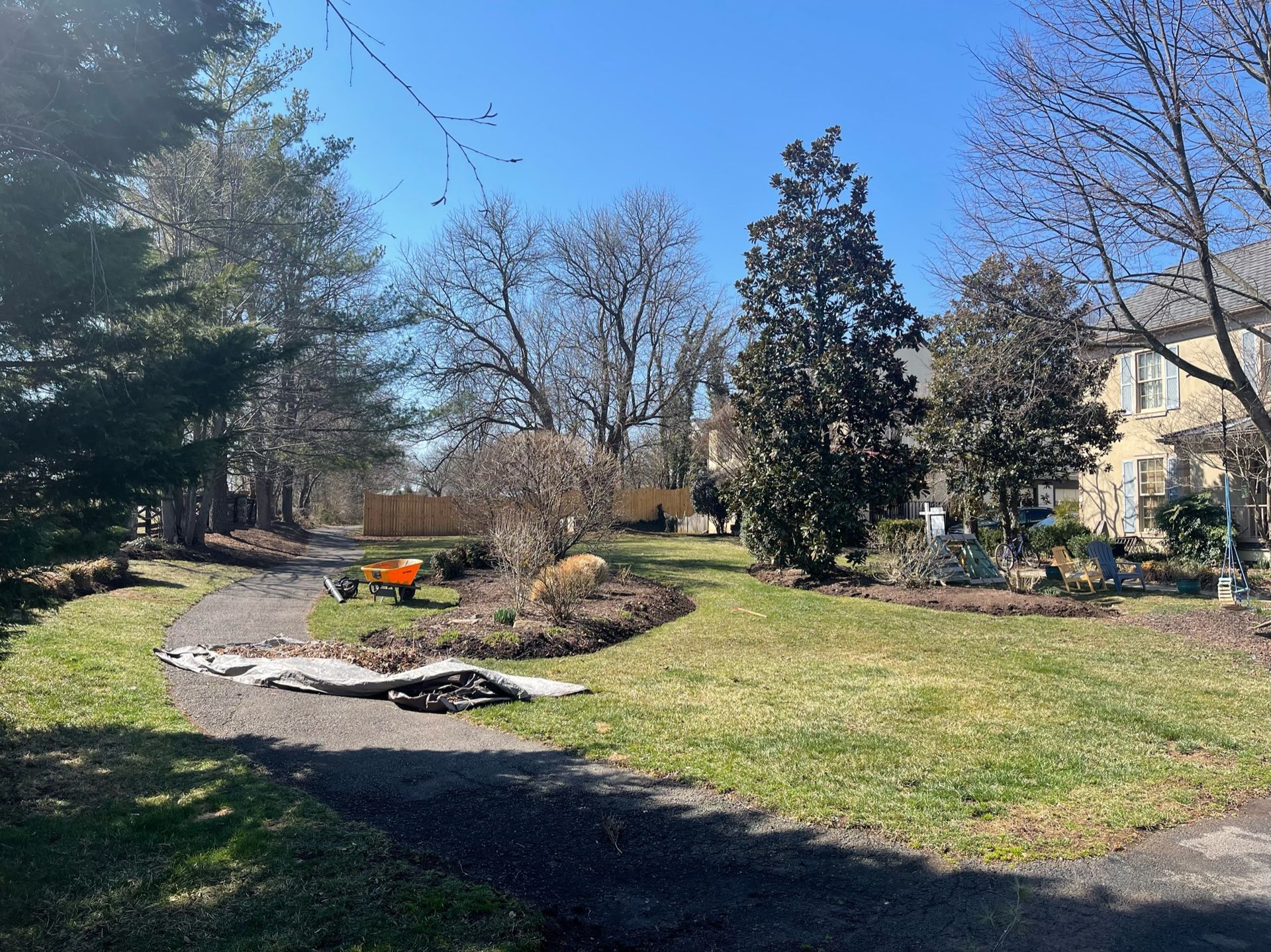 A large yard with a house in the background and trees in the foreground.