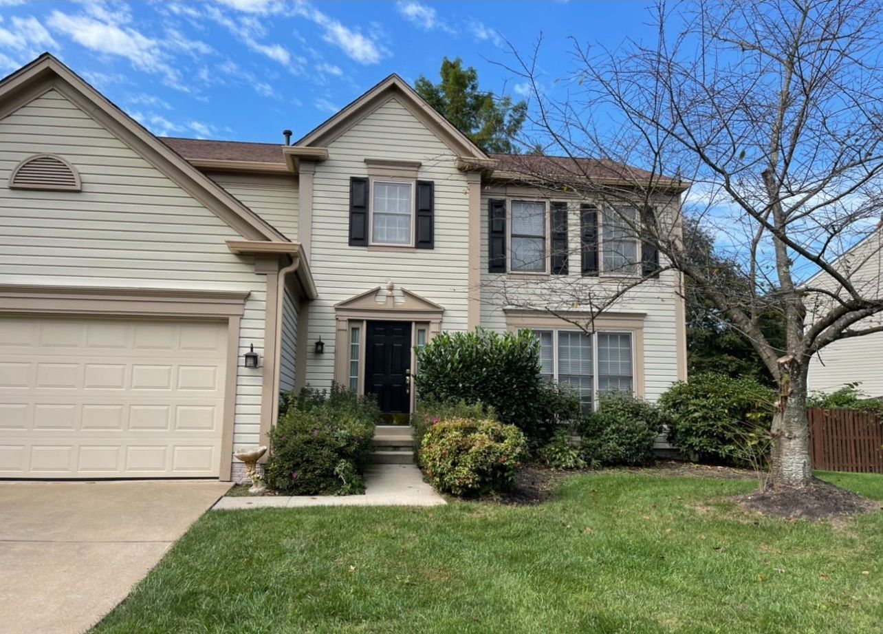 The front of a house with a large garage and a lush green lawn.