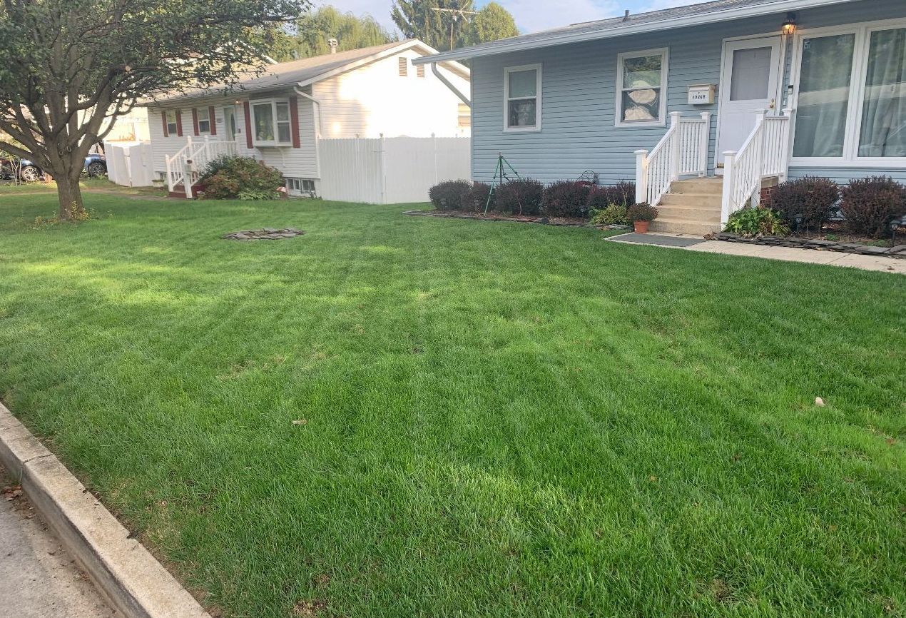 A house with a lush green lawn in front of it.