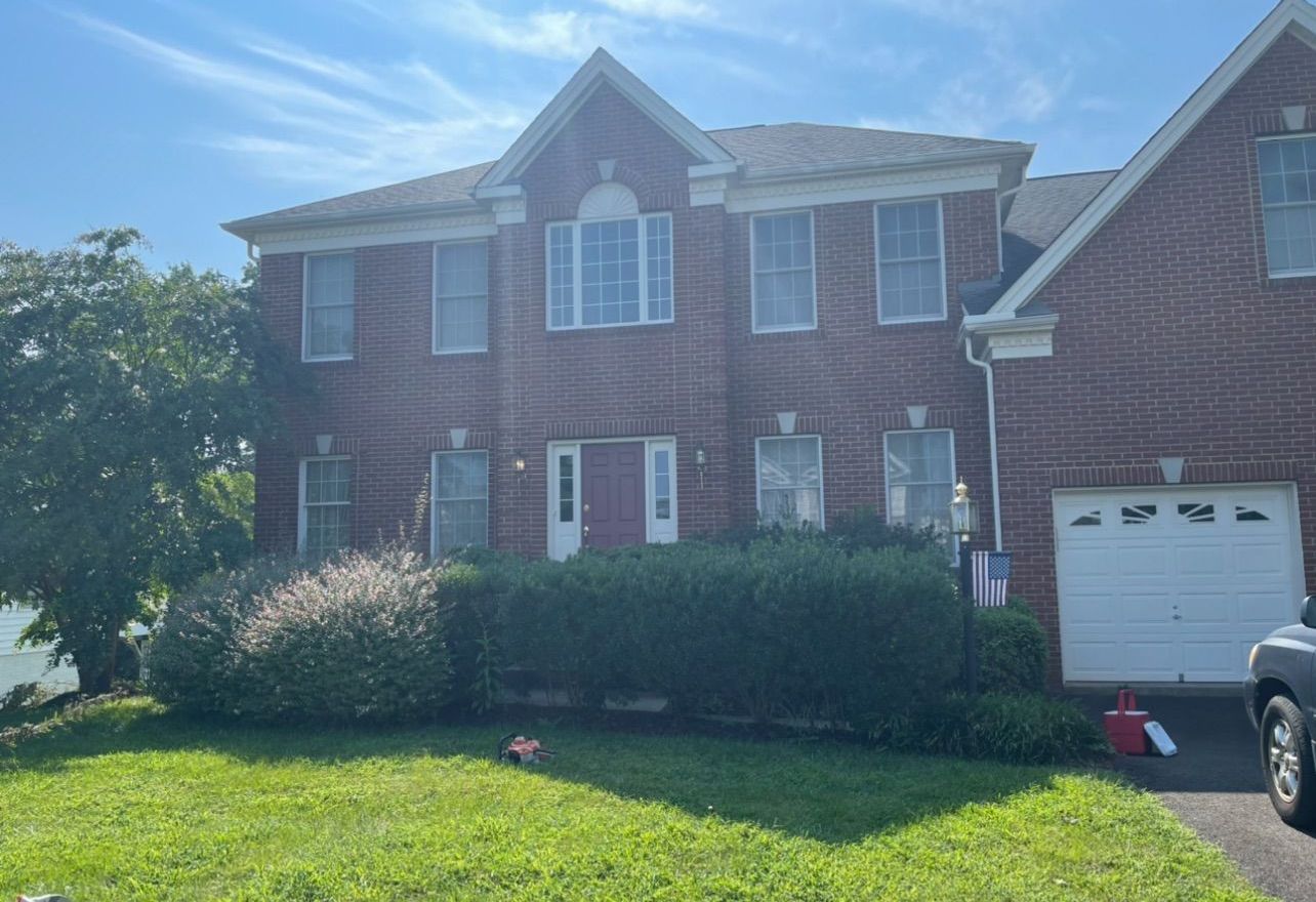 A large brick house with a car parked in front of it