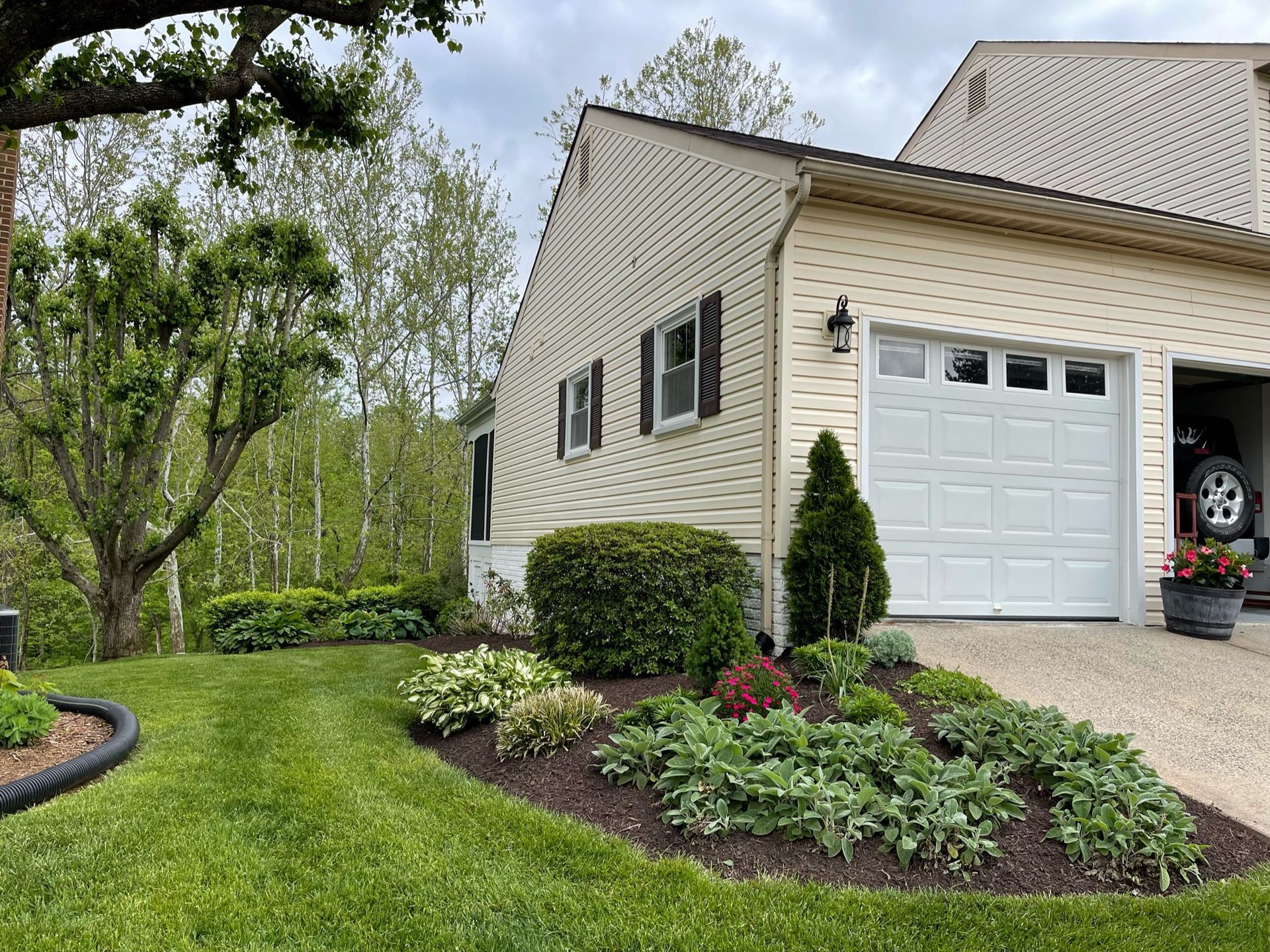 A house with a white garage door and a car parked in the garage.