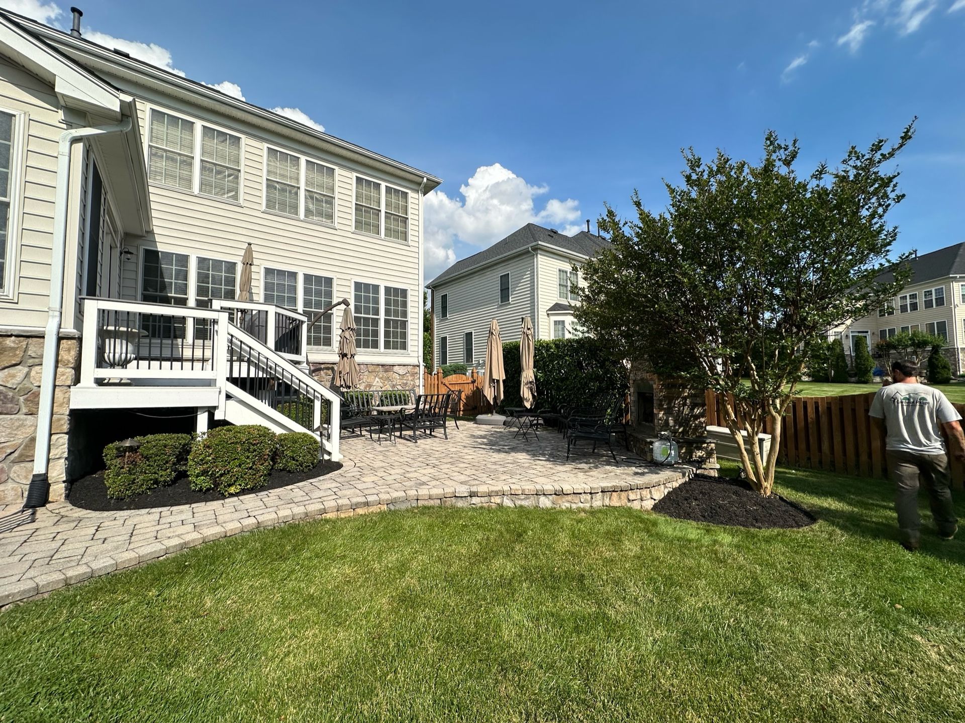 A man is standing in front of a house with a patio.