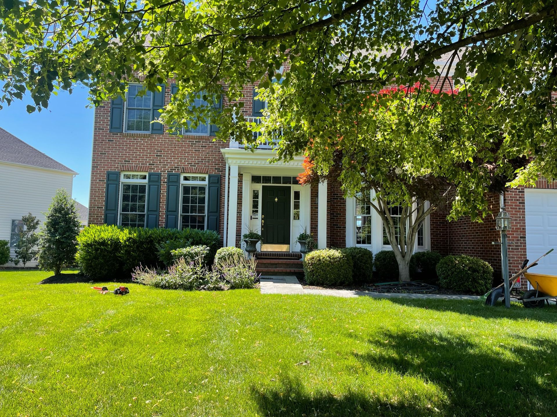 A large brick house with a large lawn in front of it.