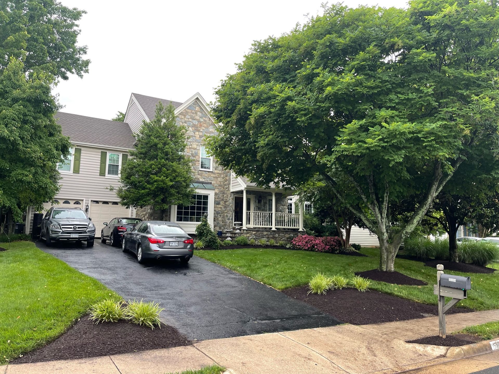 A house with cars parked in front of it and a mailbox.