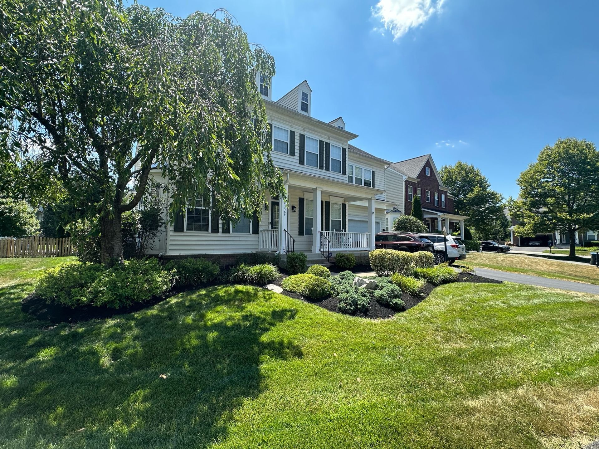 A large white house with a large lawn in front of it.