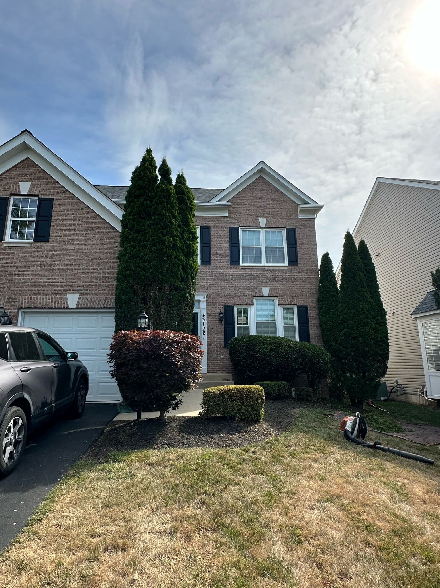 A brick house with a car parked in front of it