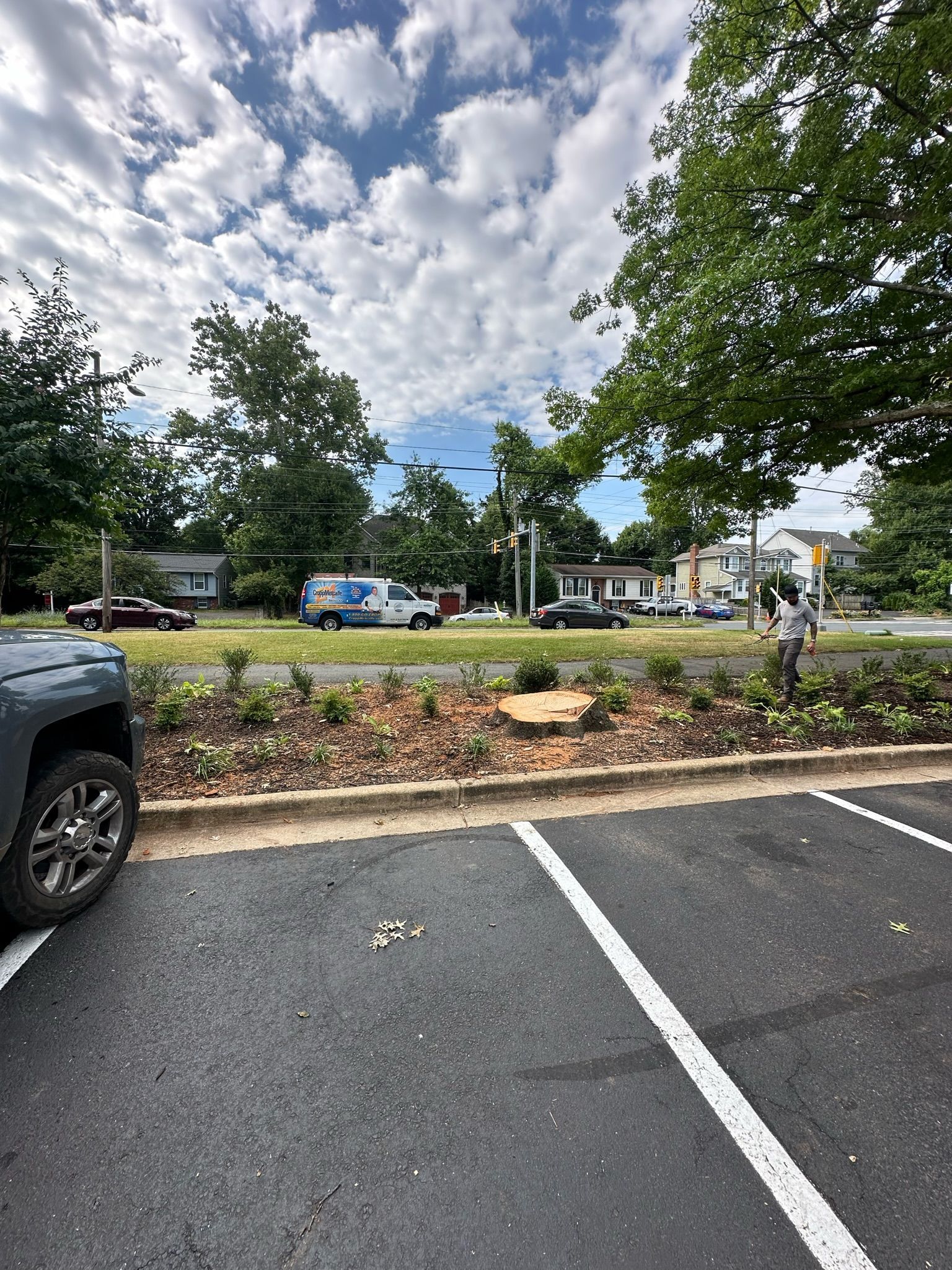 A car is parked in a parking lot with trees in the background