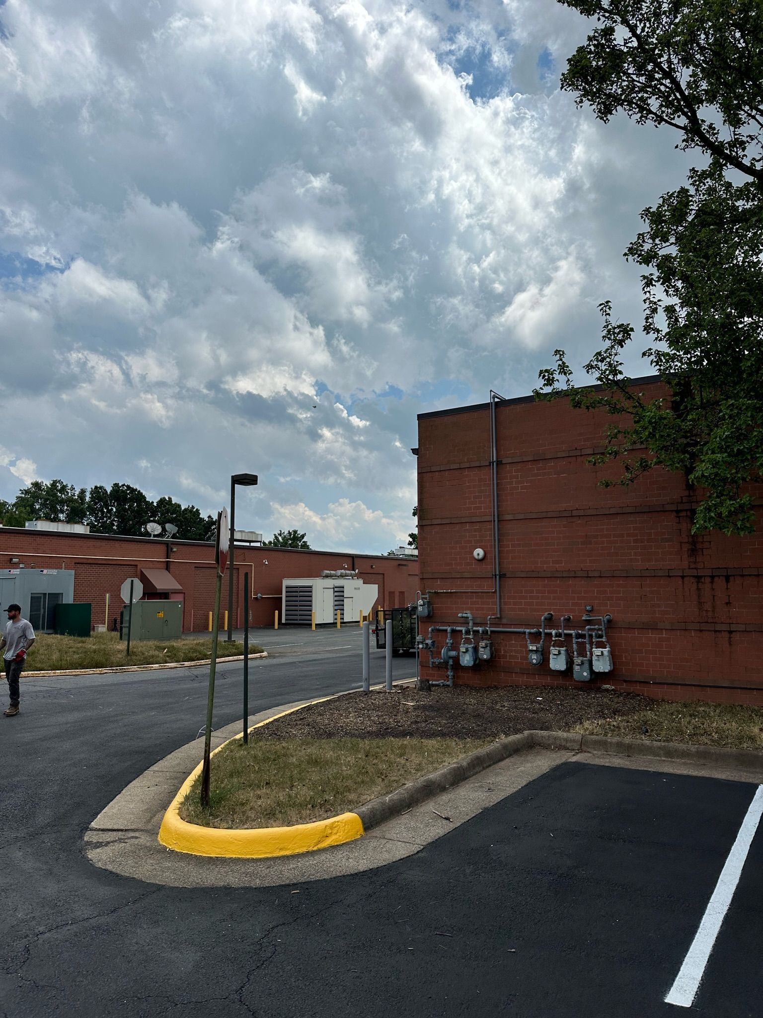 A parking lot with a brick building in the background