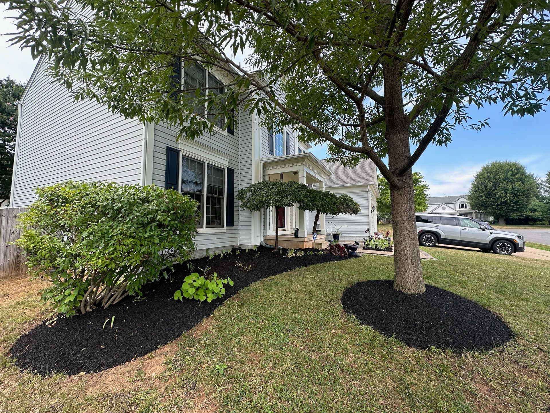 A white house with a car parked in front of it.