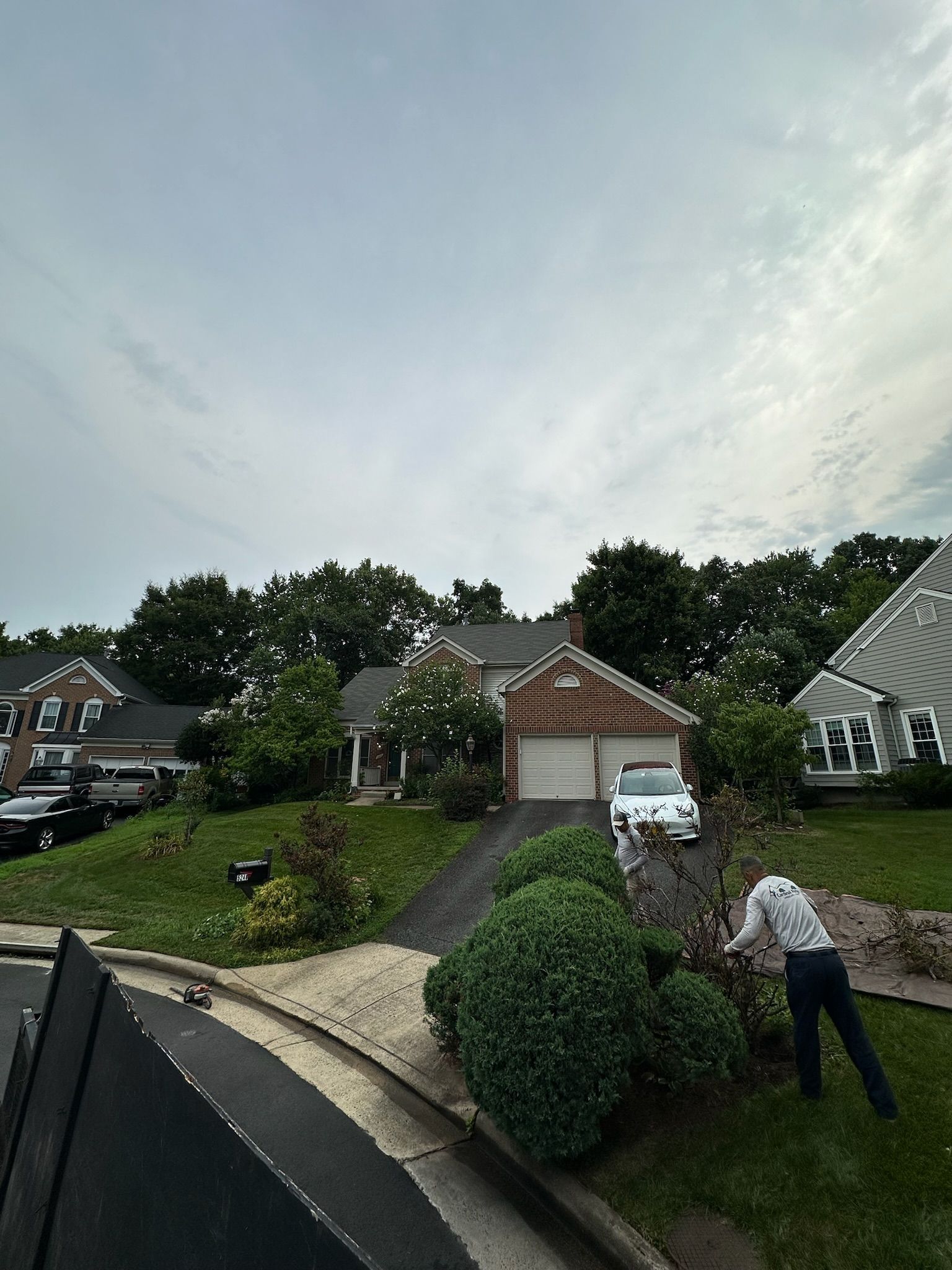 A man is standing in front of a house in a residential area.