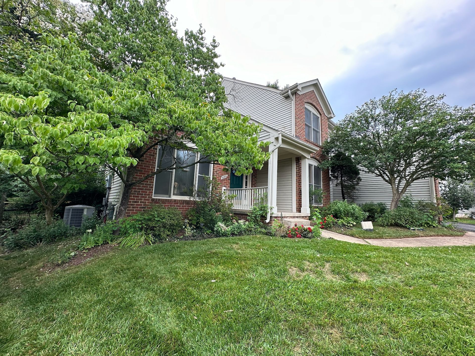 A large brick house with a large lawn in front of it.
