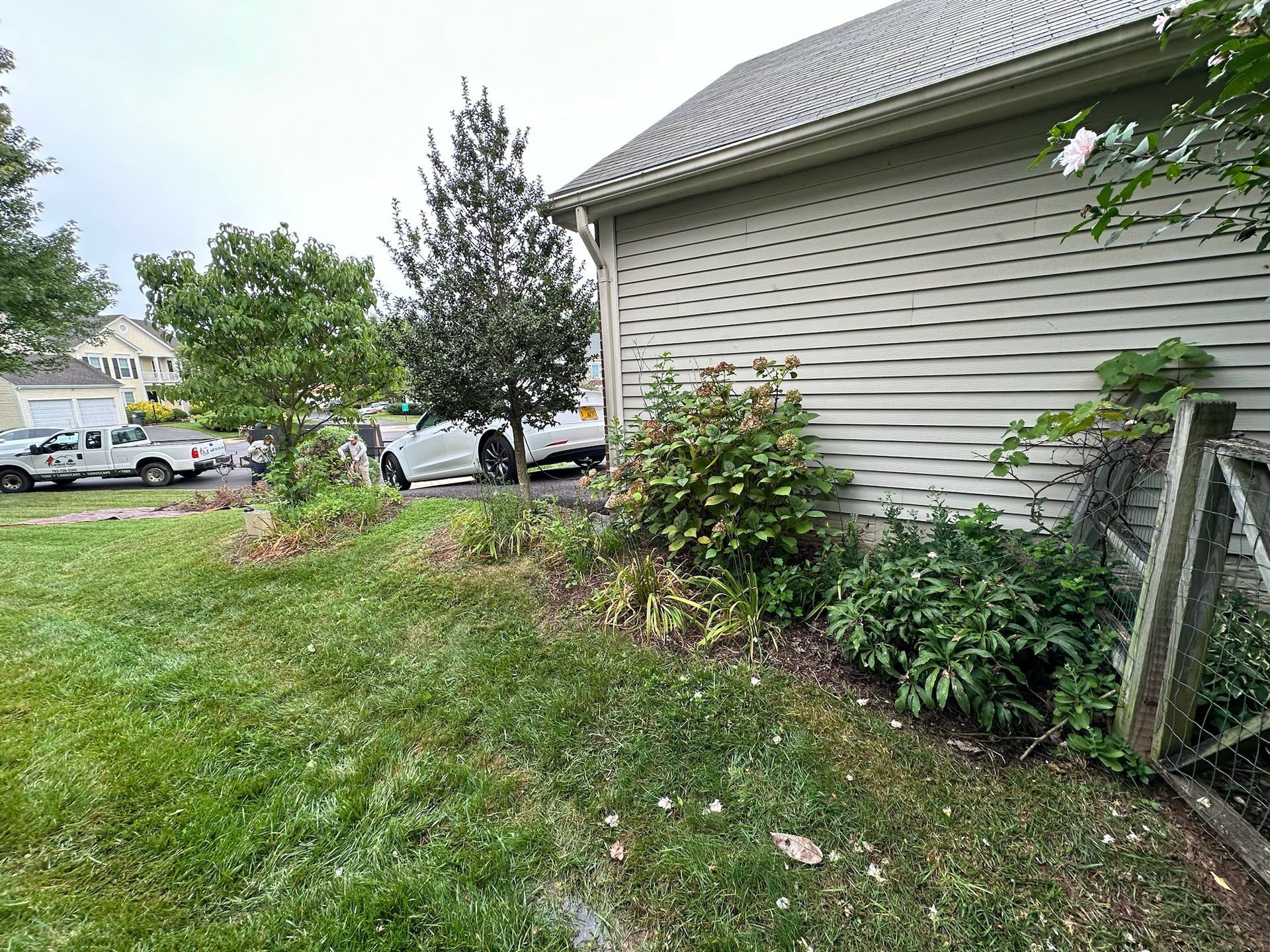 A white car is parked in front of a house.