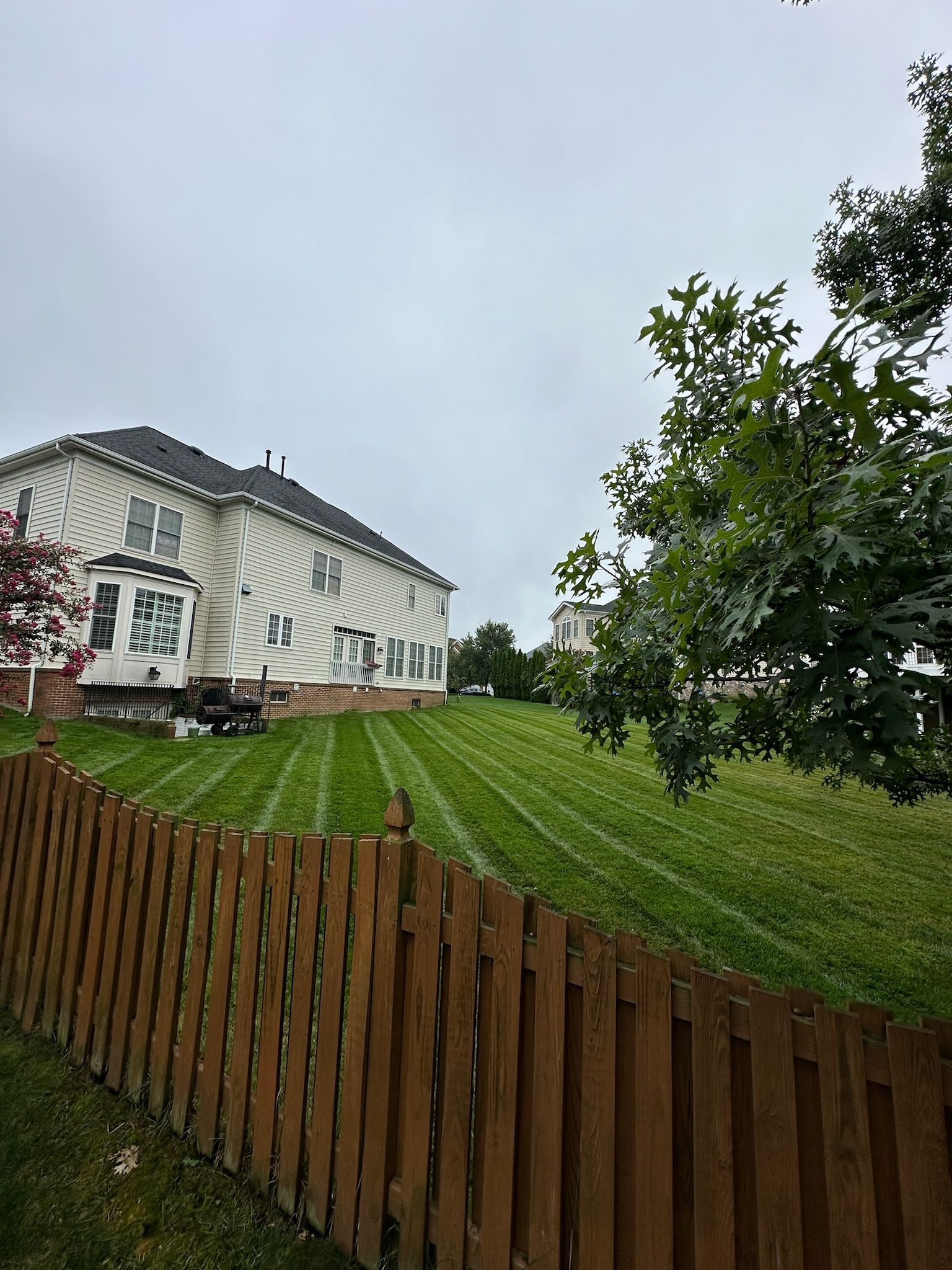 A large white house with a wooden fence in front of it.
