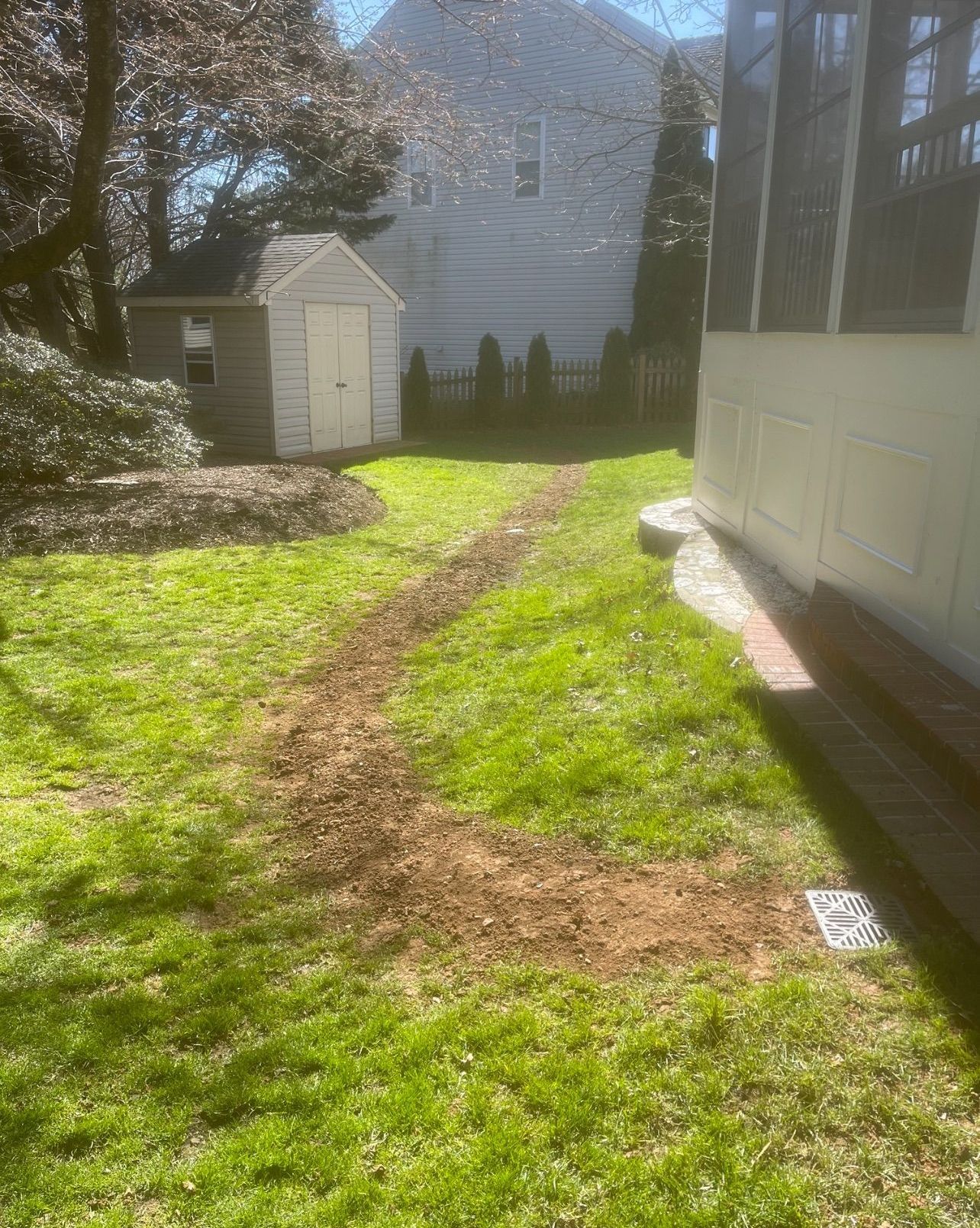 A backyard with a shed and a path leading to it.