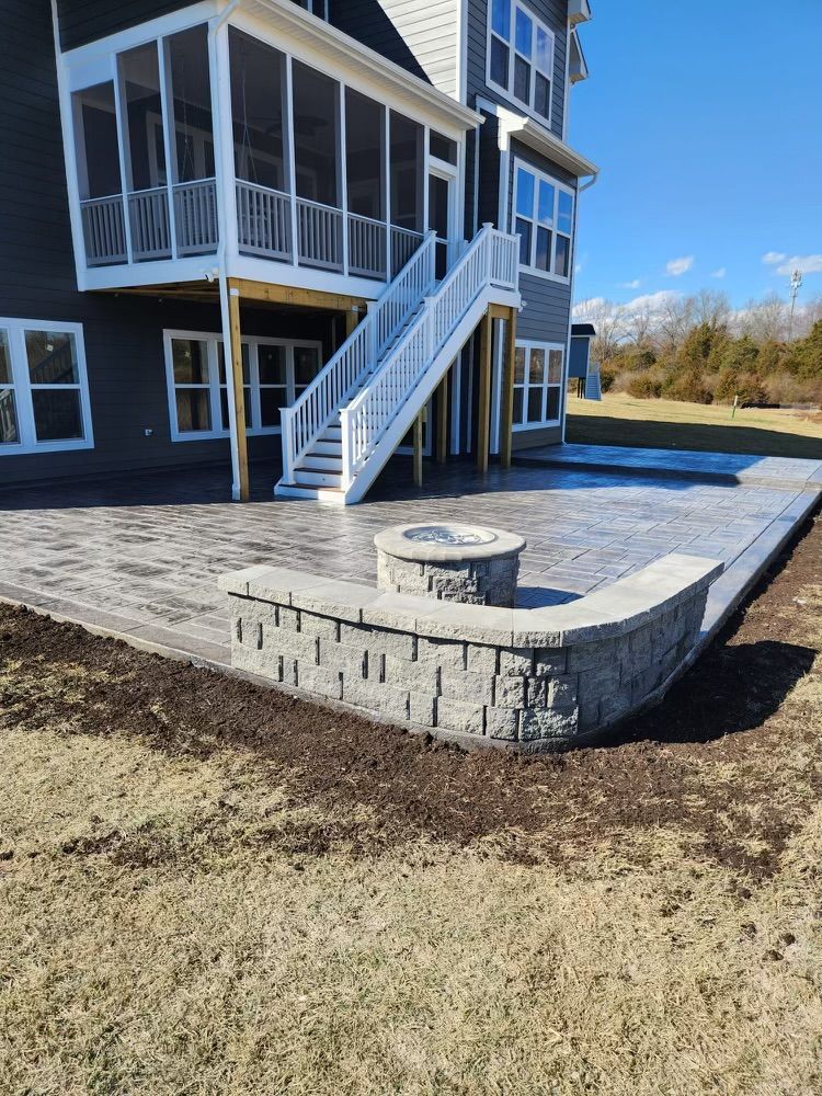 A large house with a screened in porch and a fire pit in front of it.