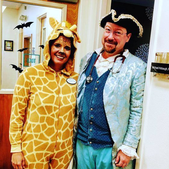 A man and a woman are posing for a picture in front of an exit sign