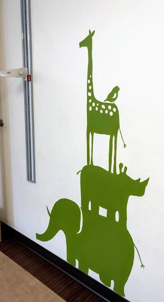 A shadow of a giraffe elephant and rhino on a wall