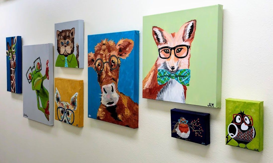 A row of paintings of animals are hanging on a wall.