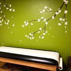 A green wall with white flowers painted on it.