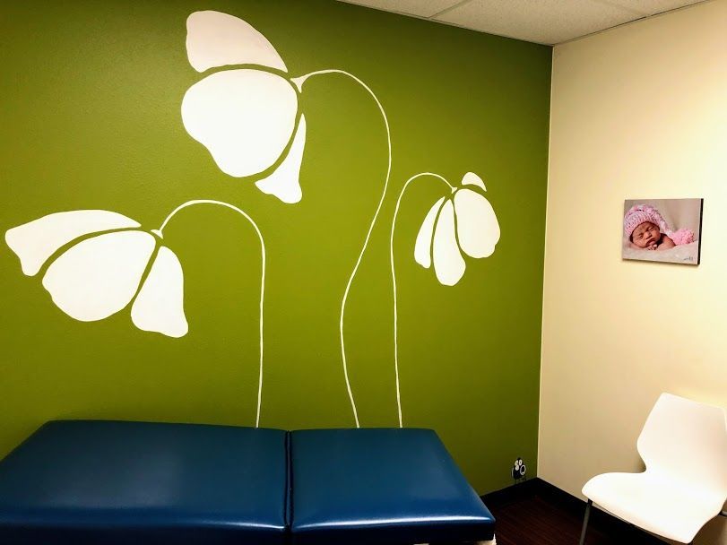 A green wall with white flowers painted on it