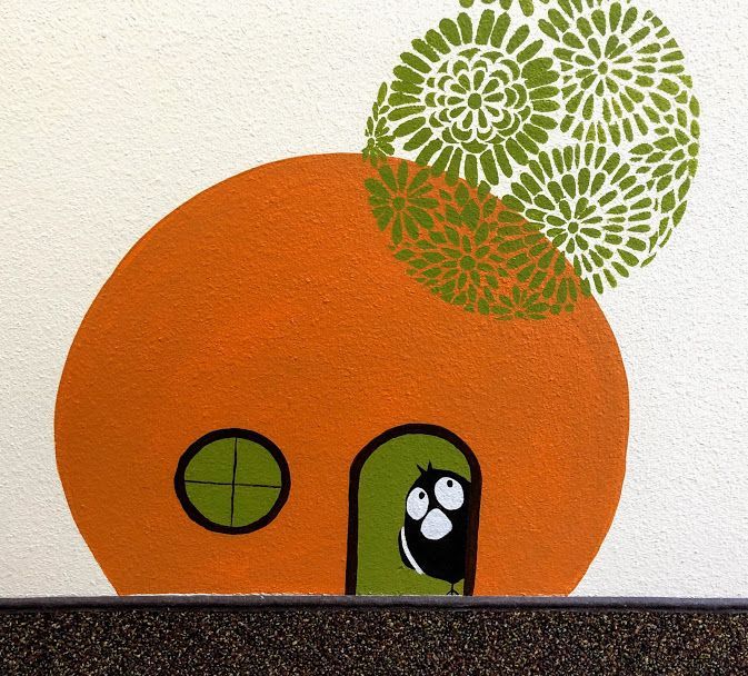 A drawing of a house with a bird looking out the door