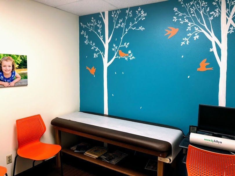 A blue wall with trees and birds painted on it