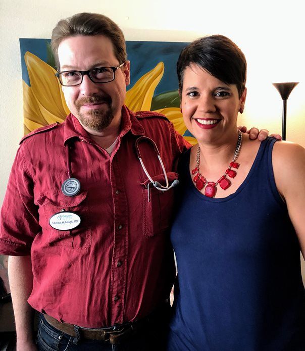 A man in a red shirt and a woman in a blue tank top are posing for a picture