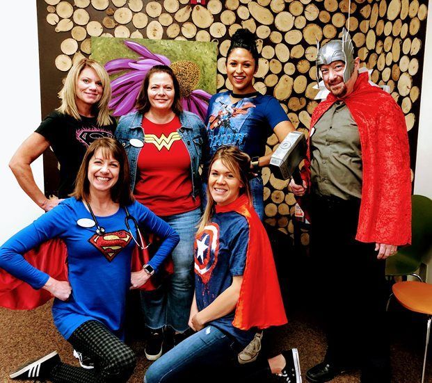 A group of people dressed in superhero costumes are posing for a picture