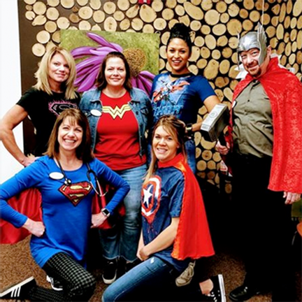 A group of people dressed in superhero costumes pose for a picture