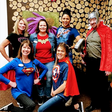Staff in superhero costumes