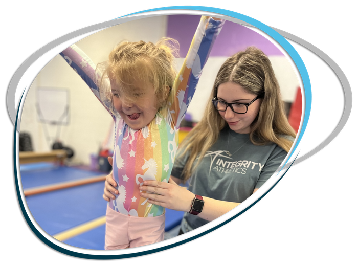 A woman is helping a little girl do a trick on a balance beam.