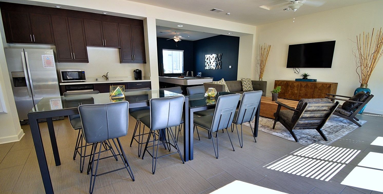 A living room with a dining table and chairs and a kitchen