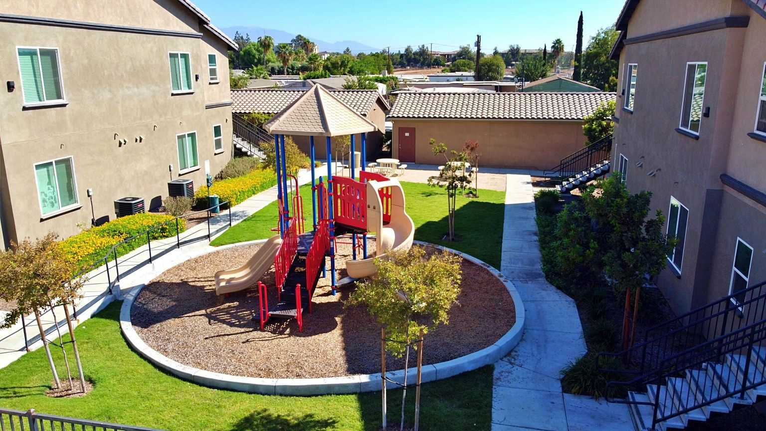 An aerial view of a playground in front of a building