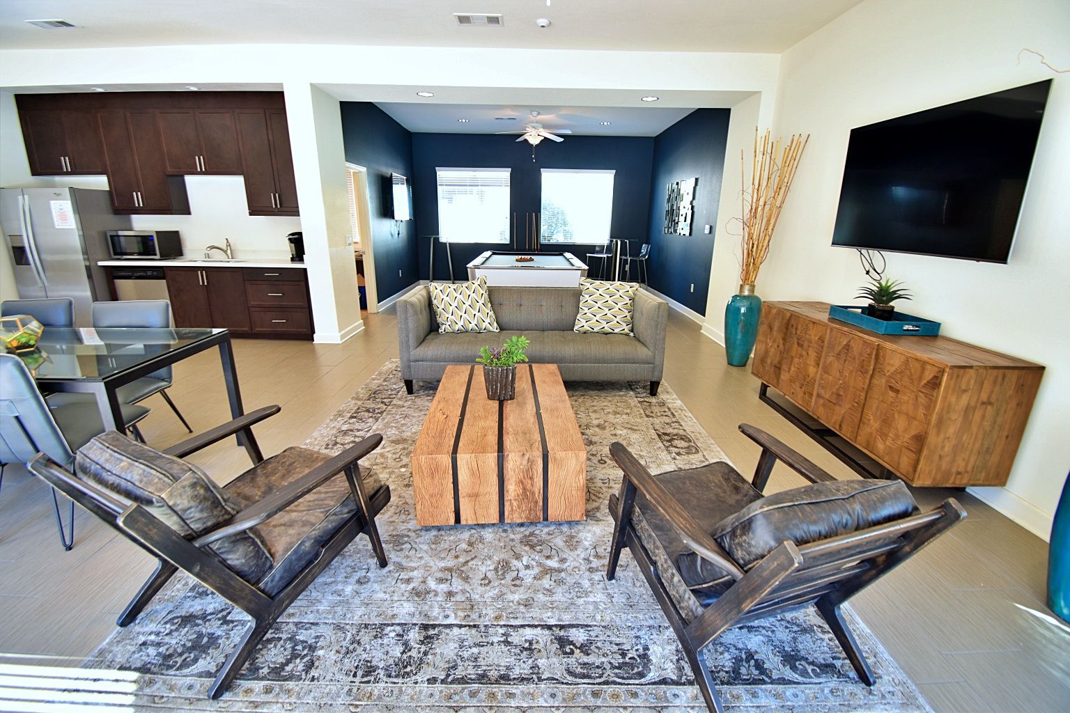 A living room with a couch , chairs , table and television.