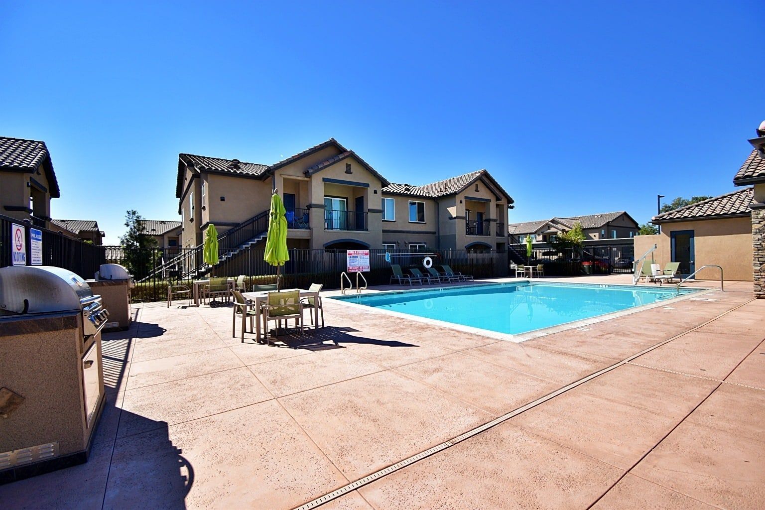 a large building with a pool and umbrellas in front of it