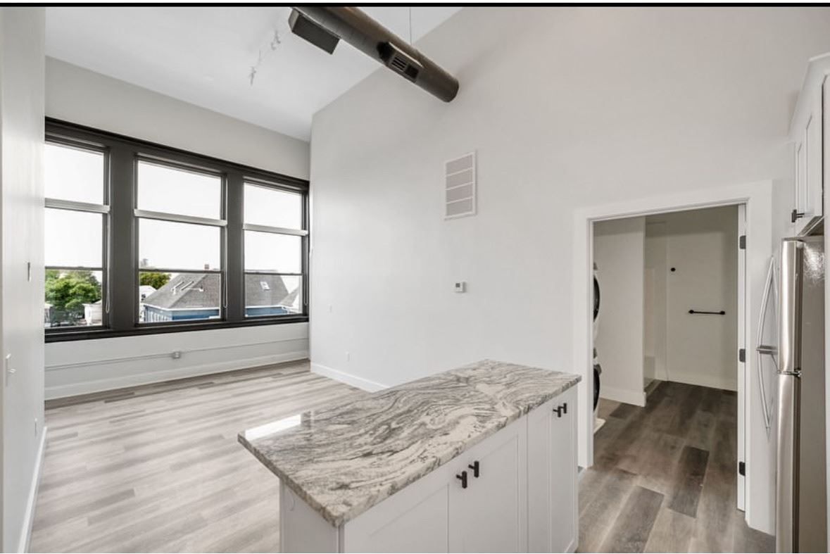 A kitchen with a granite counter top and stainless steel appliances.