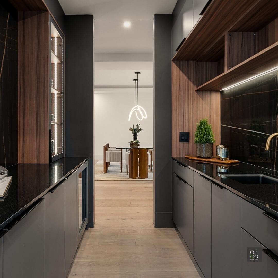 A kitchen with a sink and a dining room in the background