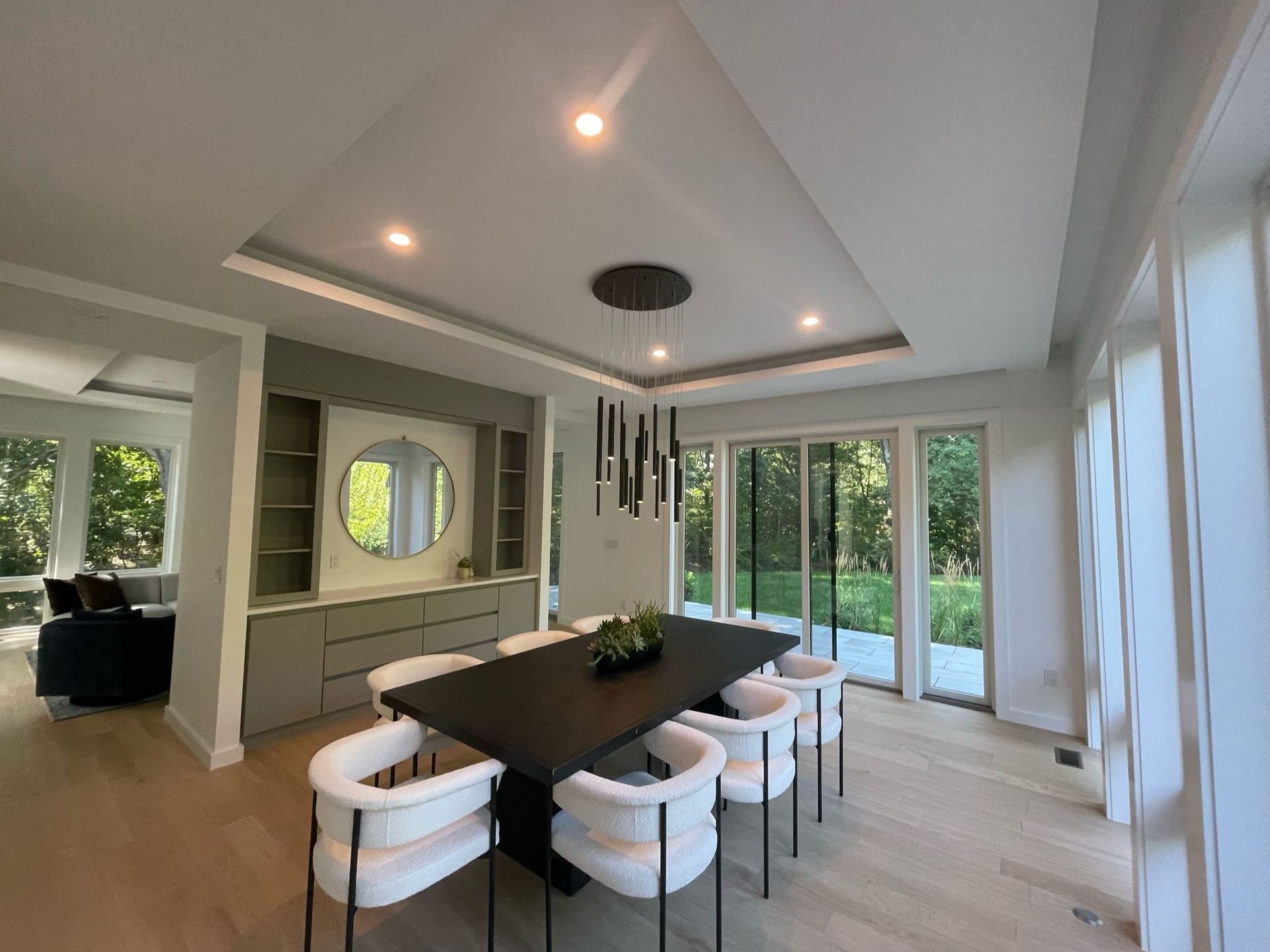 A dining room with a black table and white chairs