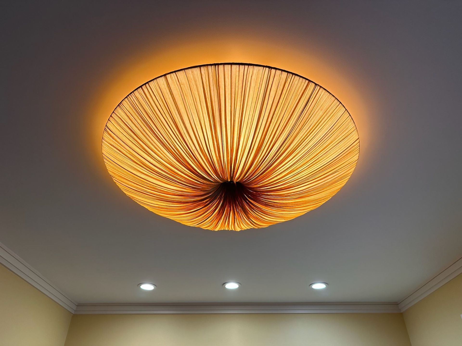 A large light fixture is hanging from the ceiling in a room.