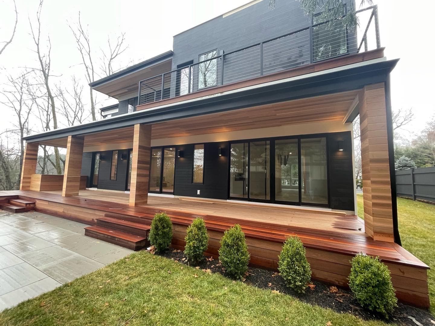 The back of a house with a large porch and stairs.
